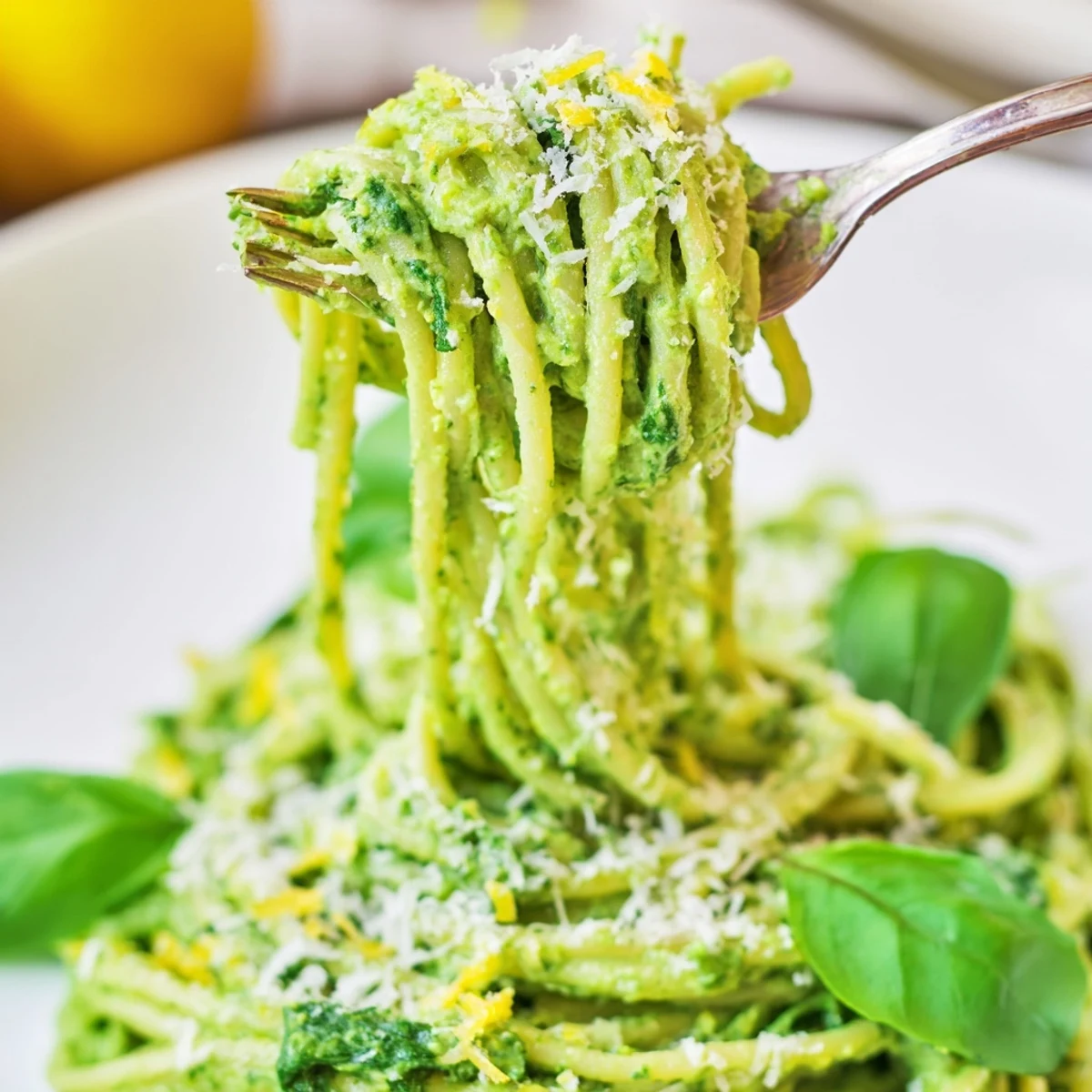 Creamy avocado and spinach spaghetti is served with extra Parmesan and black pepper for a quick, nourishing weeknight meal.