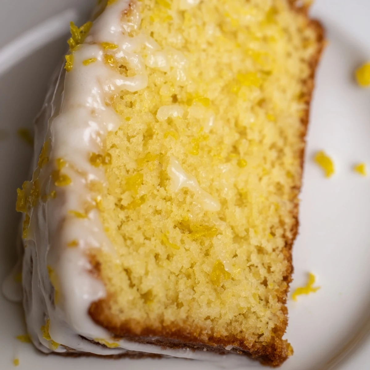 Homemade Lemon Loaf Cake with Icing on a rustic wooden table, paired with a glass of iced tea for serving.