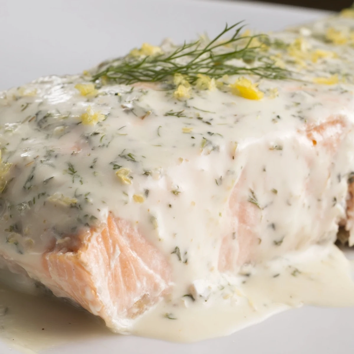 Freshly baked Baked Salmon with Creamy Dill and Lemon Sauce plated beside crisp roasted asparagus spears.