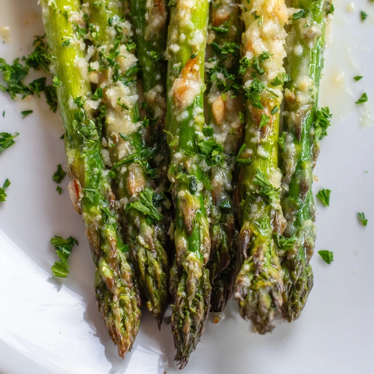 Savory Garlic Parmesan Roasted Asparagus Spears garnished with fresh parsley and shaved cheese.