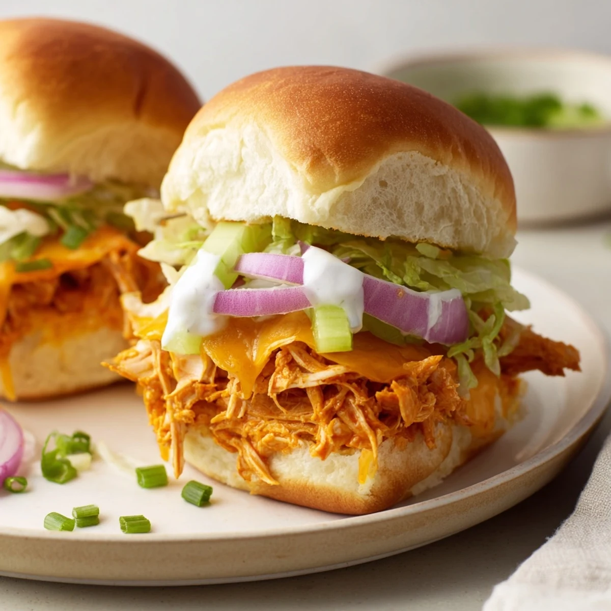The Buffalo Chicken Sliders with Ranch Dressing feature melted cheddar, crunchy celery, and a tangy kick perfect for game day gatherings.  