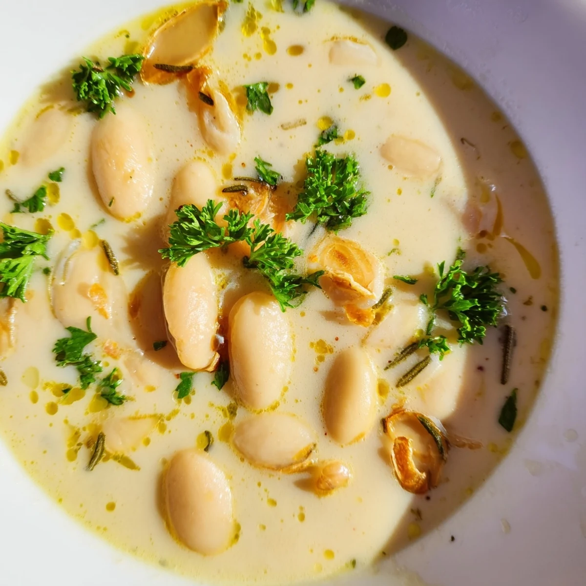 A hearty bowl of Rosemary and Roasted Garlic White Bean Soup with crusty bread for dipping.
