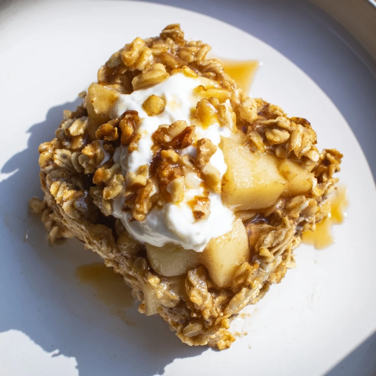 A warm slice of Baked Apple Oatmeal With Greek Yogurt showcases tender baked oats and juicy diced apples.