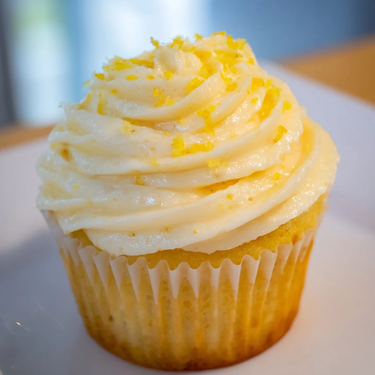 Limoncello Cupcakes on a rustic wooden board, their golden crumbs moist with syrup and bright Italian lemon flavor.