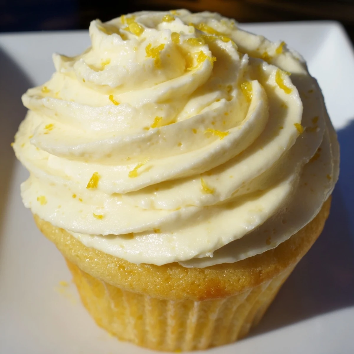 Twelve Limoncello Cupcases arranged on a white platter, perfect for a refreshing summer dessert or sunny outdoor gathering.