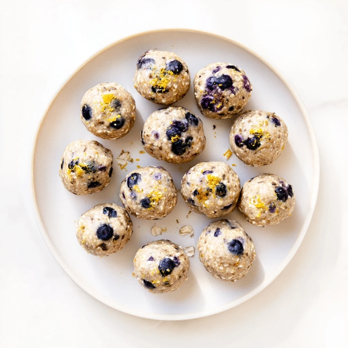 These bite-sized Blueberry Cheesecake Protein Bites showcase oats and protein powder for a healthy snack.