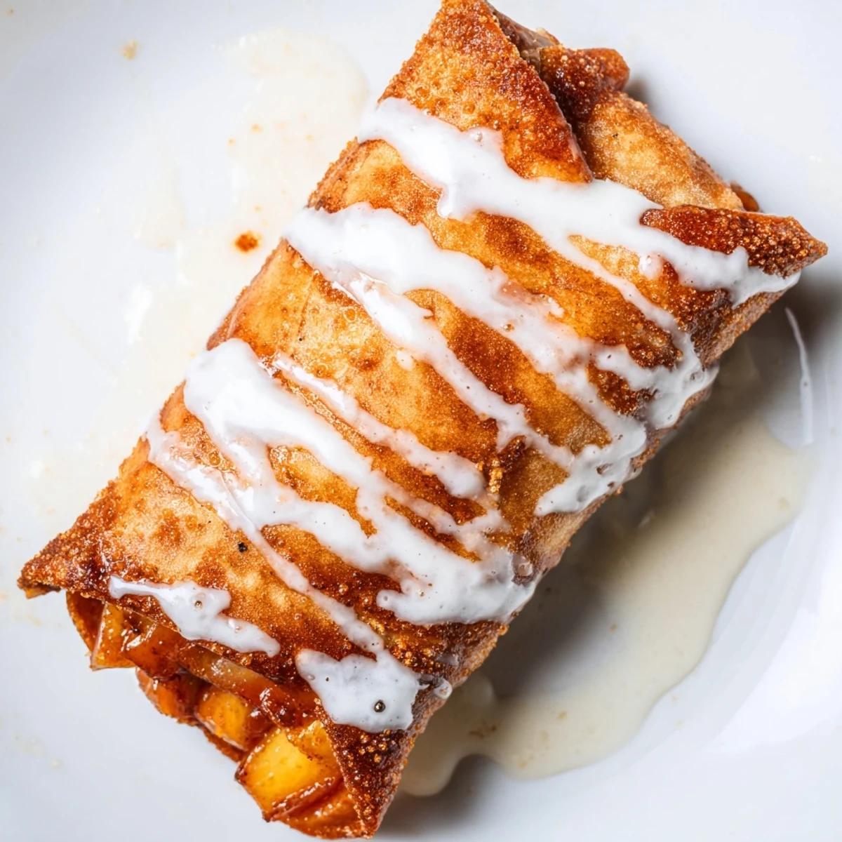 Peach Cobbler Egg Rolls with warm cinnamon peaches peeking out of a crunchy fried wrapper, ready to eat.