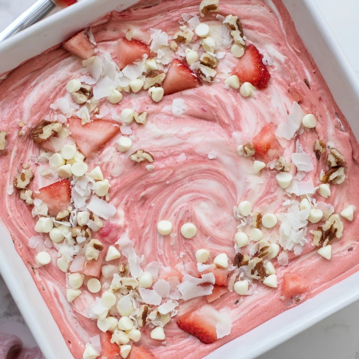 Sliced strawberry earthquake cake showing its creamy swirled interior on a white serving plate