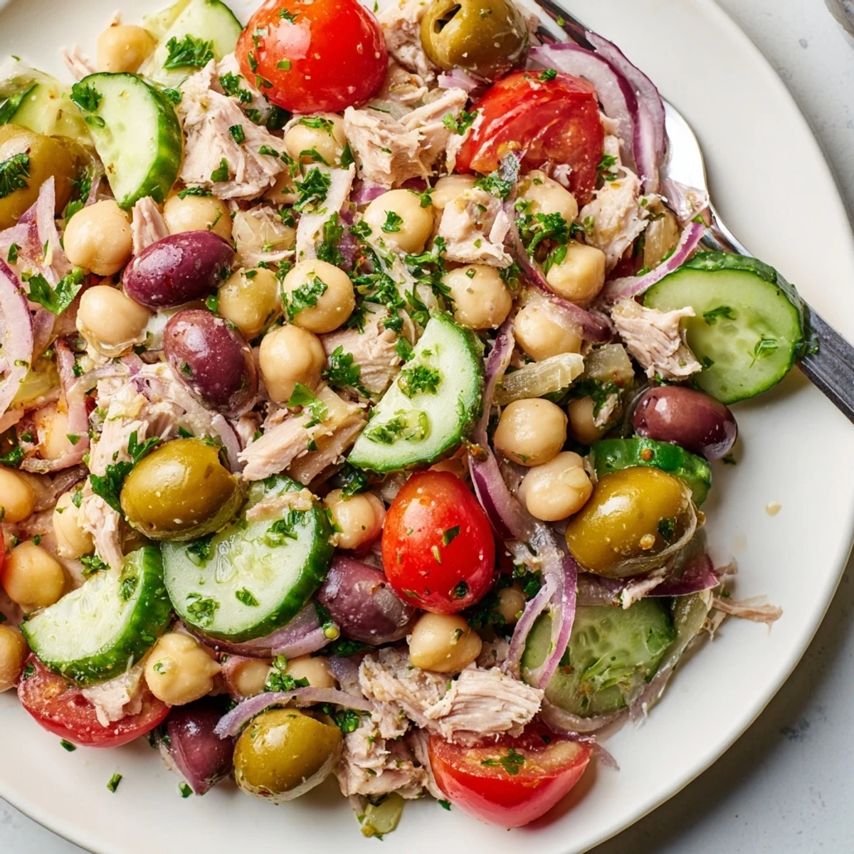 Protein-rich tuna and garbanzo bean salad topped with vibrant parsley and kalamata olives