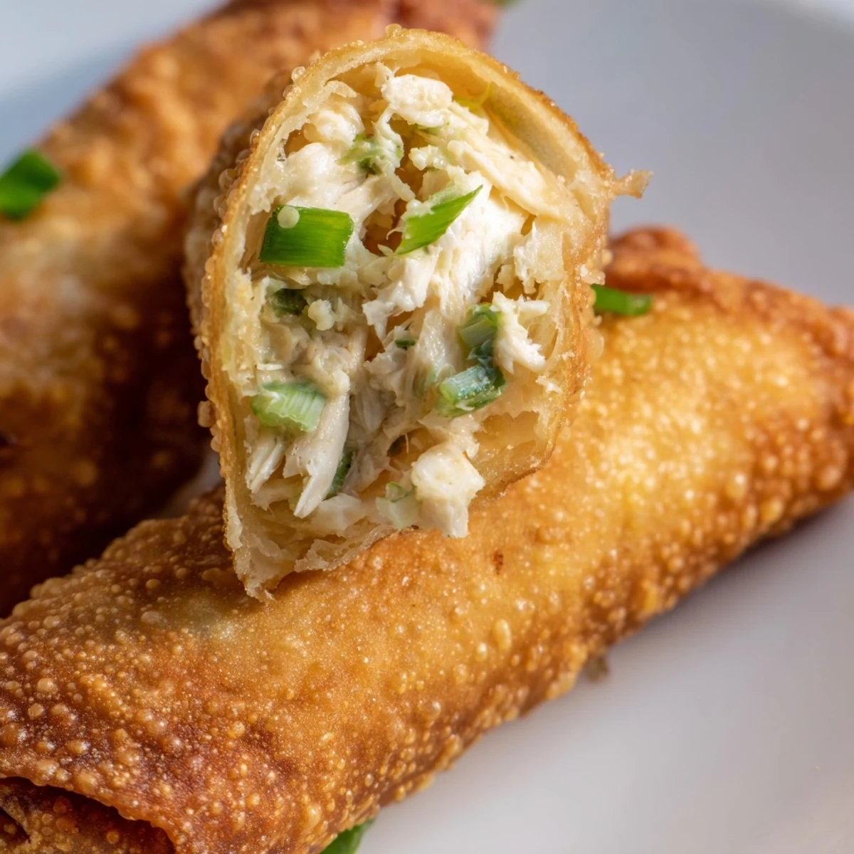 Golden fried Crab Rangoon egg rolls with creamy crab and cream cheese filling