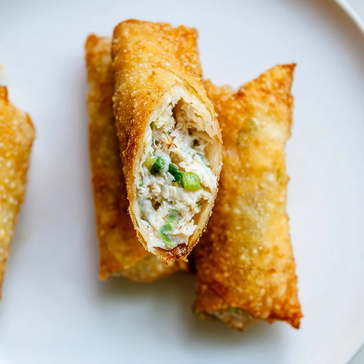 Plate of hot Crab Rangoon egg rolls displaying golden brown fried pastry shells