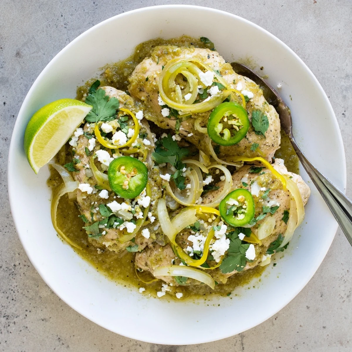 Golden pan-seared chicken breasts swimming in vibrant green salsa verde sauce with fresh cilantro garnish