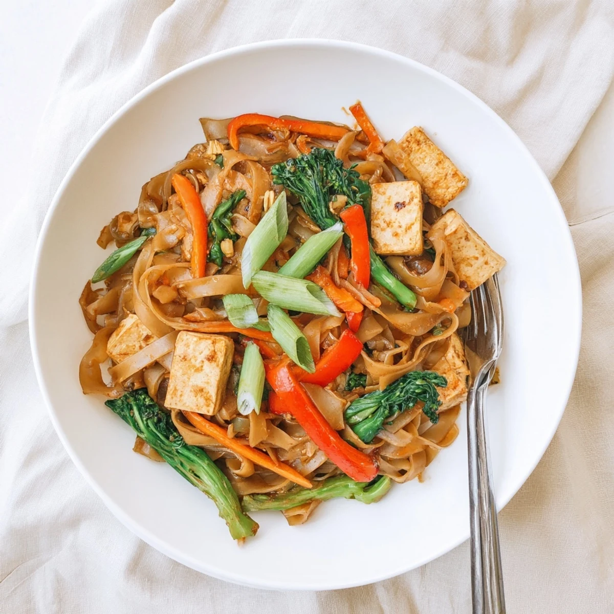 Vegan Pad See Ew featuring wide rice noodles stir-fried with crisp Chinese broccoli in savory dark soy sauce