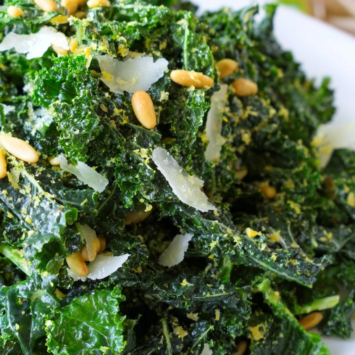 Fresh massaged kale leaves glistening with zesty garlic lemon Parmesan dressing in wooden bowl