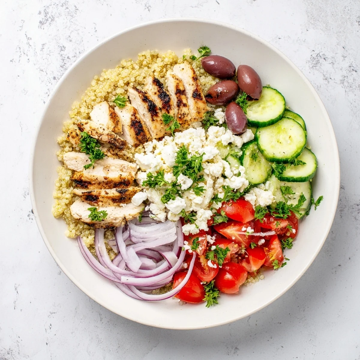 Colorful Mediterranean chicken quinoa bowl featuring fluffy grains fresh cucumber tomatoes and tangy kalamata olives