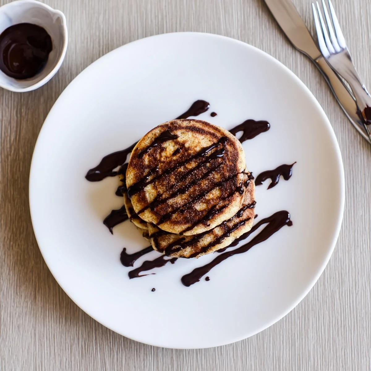 Fluffy Spanish Churro Pancakes coated in sweet cinnamon sugar served with warm dipping chocolate