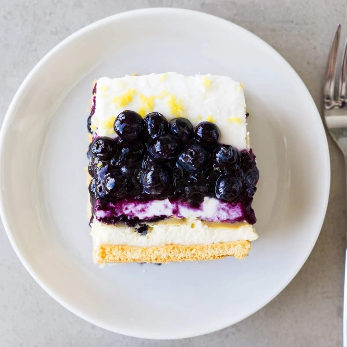 No-bake lemon blueberry lasagna garnished with fresh berries and bright lemon zest