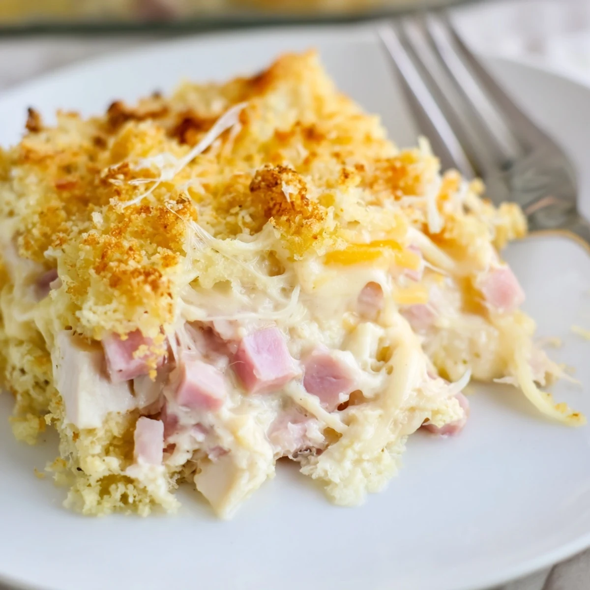 Slices of Chicken Cordon Bleu Casserole steaming, flaky ham and melted Swiss.