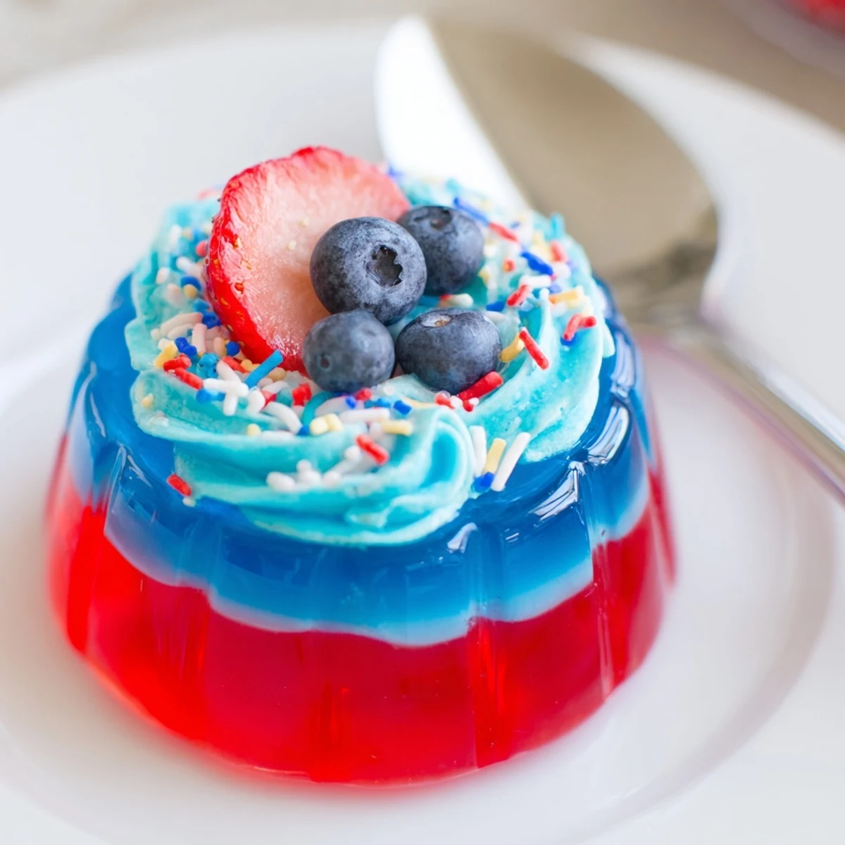 Red White And Blue Jello Cups layered in clear cups, topped with whipped cream
