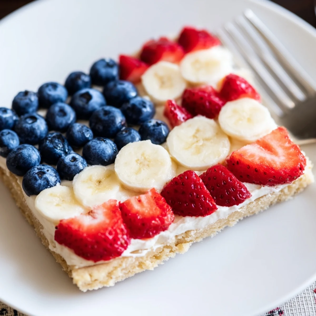 Vibrant American Flag Fruit Pizza arranged with ripe bananas, strawberries, juicy blueberries