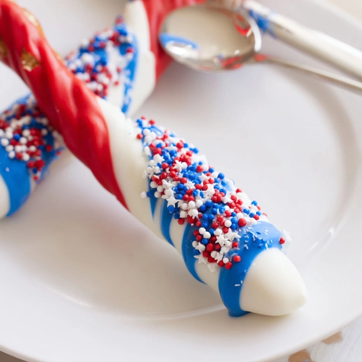 Patriotic Pretzel Rods glistening with red, white, blue chocolate and sprinkles