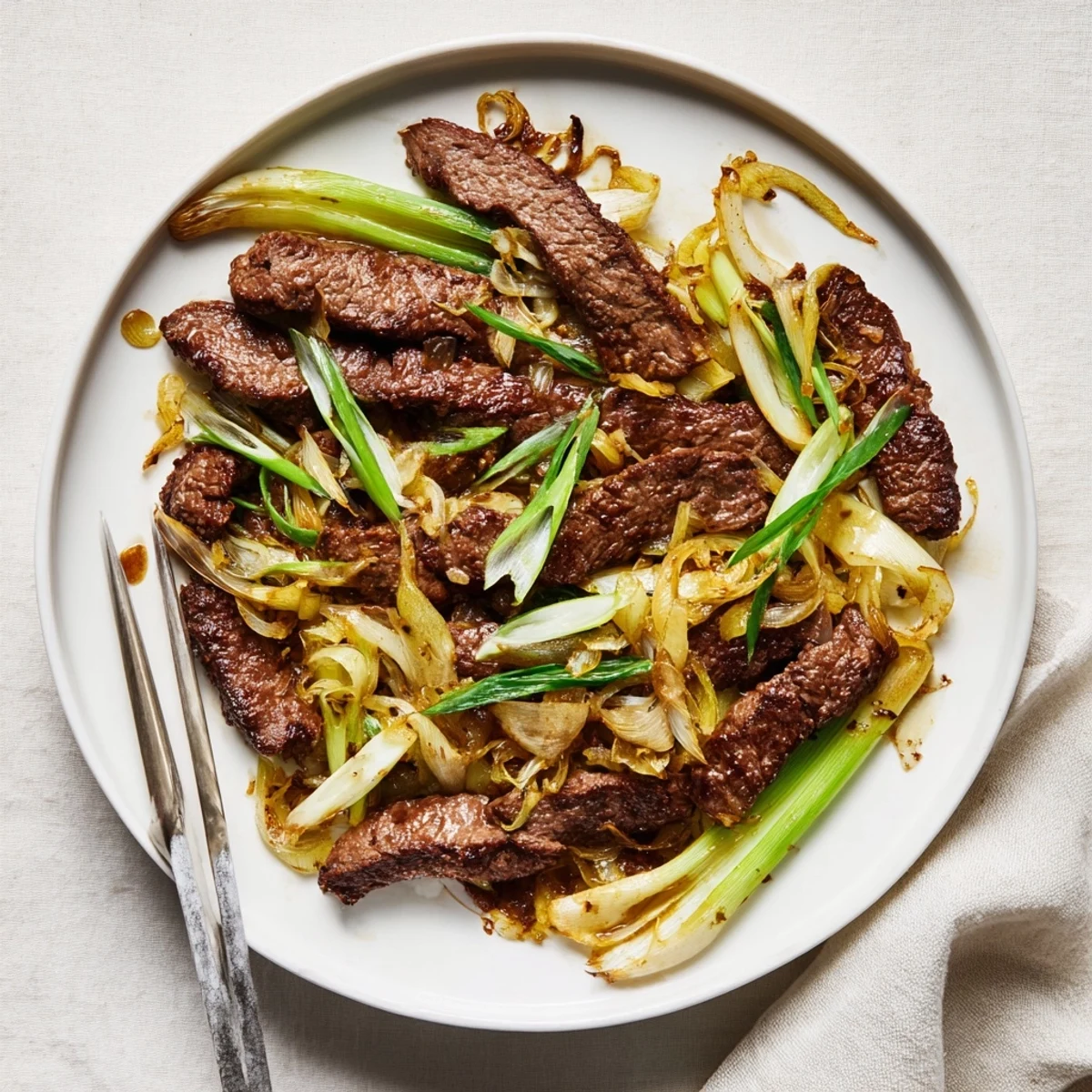 Golden brown crispy beef strips tossed with caramelized onions in a savory dark sauce