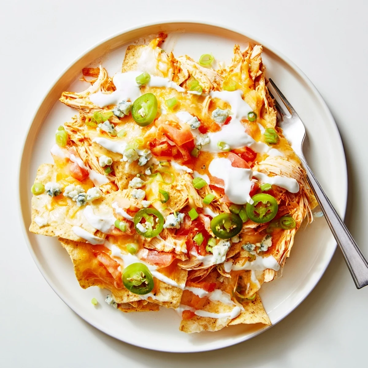 Crispy chips layered with Buffalo Chicken Nachos, spicy sauce and diced tomatoes