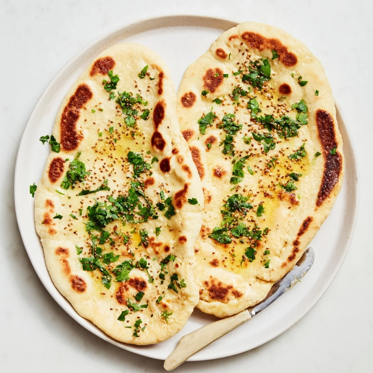 Golden brown sourdough discard soft naan brushed with melted butter and fresh cilantro