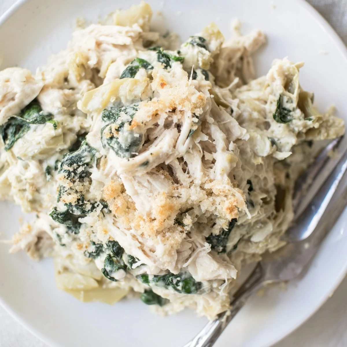 Spinach Artichoke Chicken Casserole bubbling with golden cheese, fragrant garlic and herbs