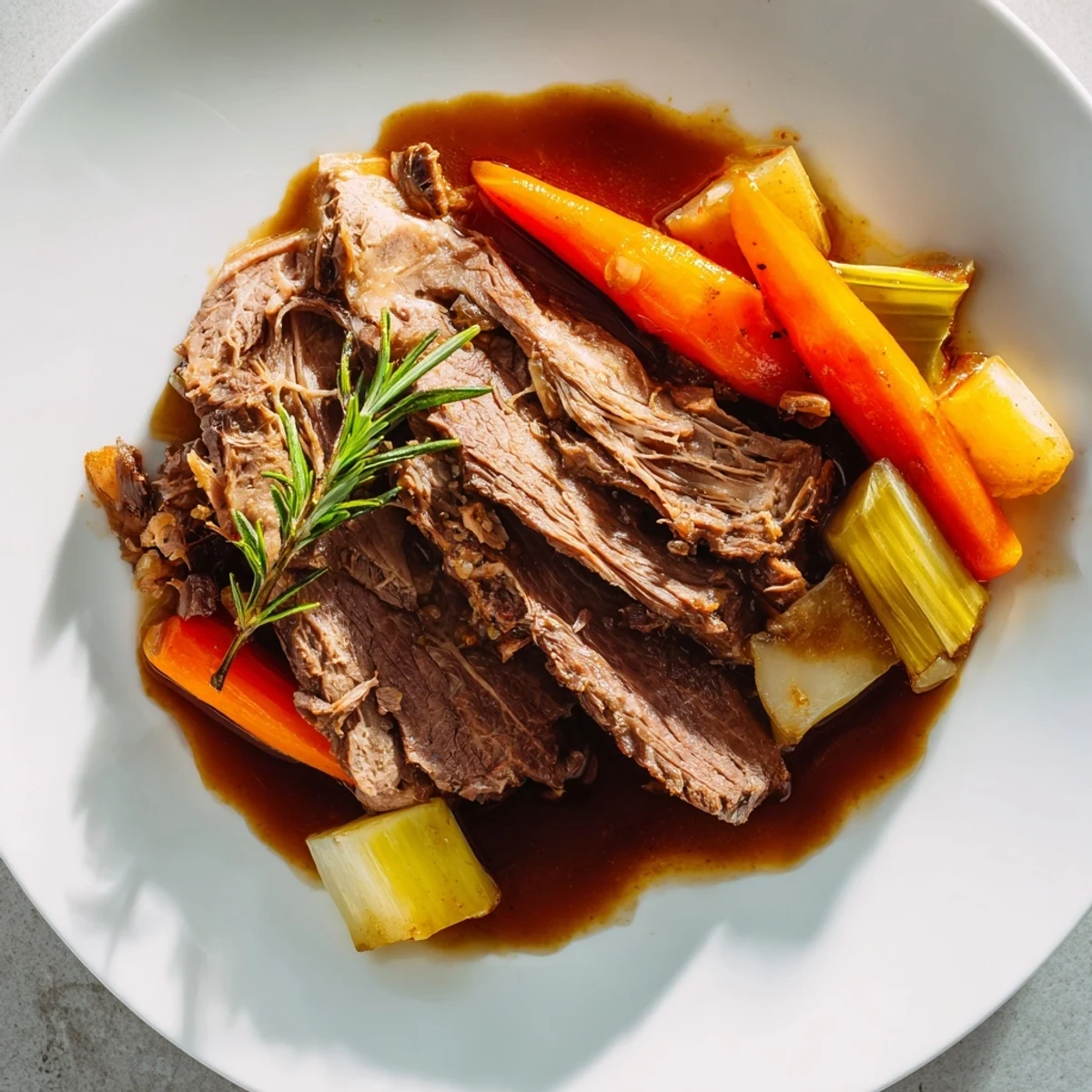 Perfect pot roast sliced thick alongside savory vegetables in rich beef gravy
