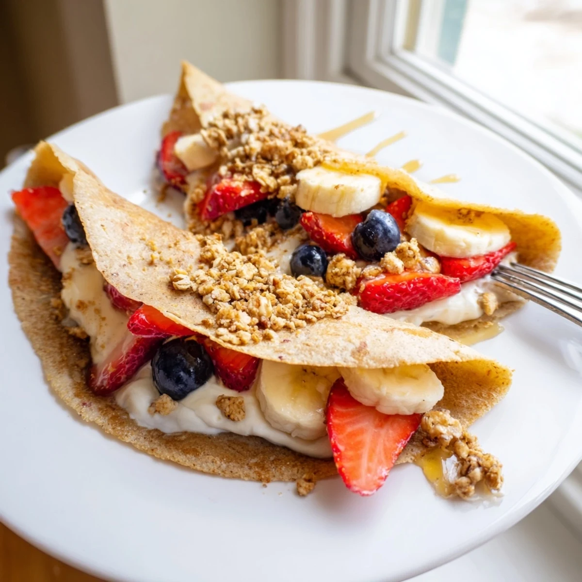 Soft pancake tacos folded around Greek yogurt, blueberries, and crunchy granola for brunch